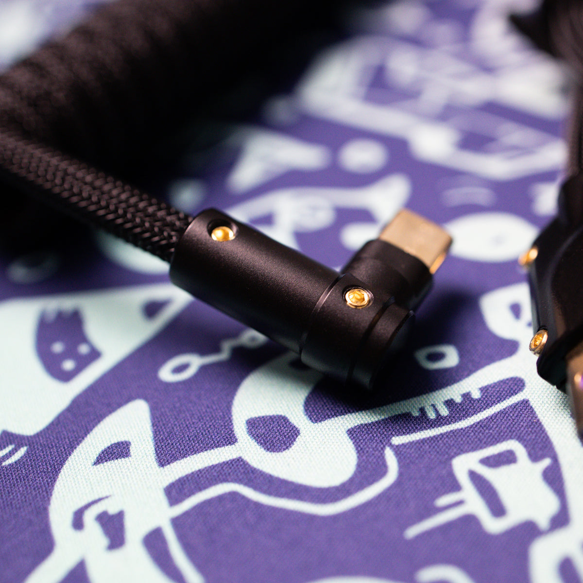 Closeup of 90 degree CNC USB C connector on a multi colored desk matt. 